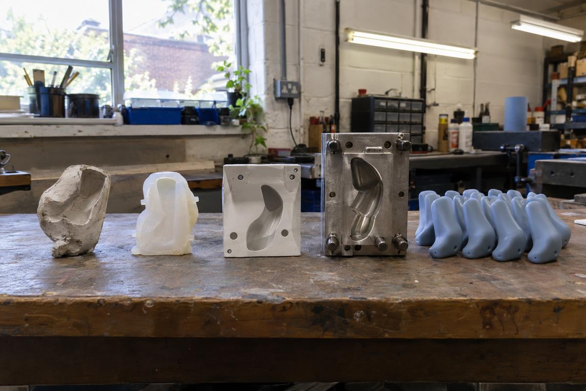 Prototype part and production tooling stages lined up on a bench