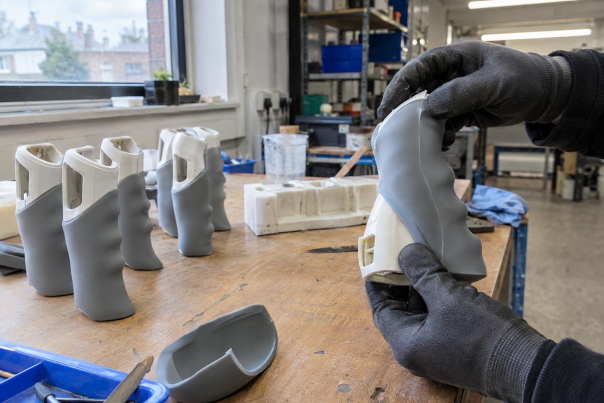 Gloved hands fitting soft cast silicone grips onto printed device shells