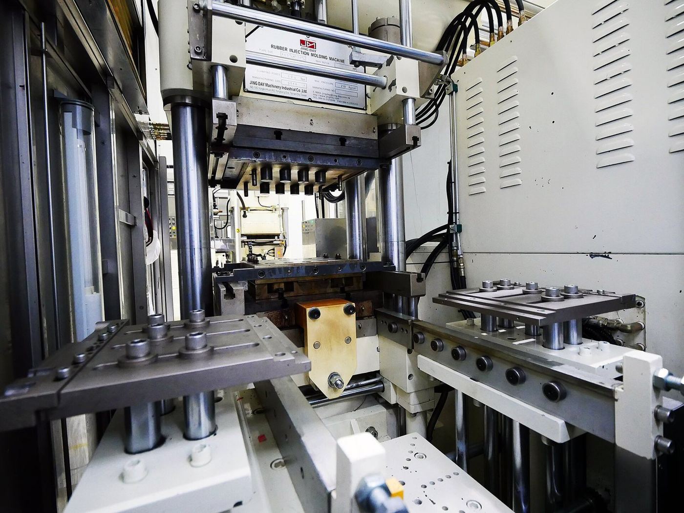 Vertical rubber compression-moulding press with tool plates.