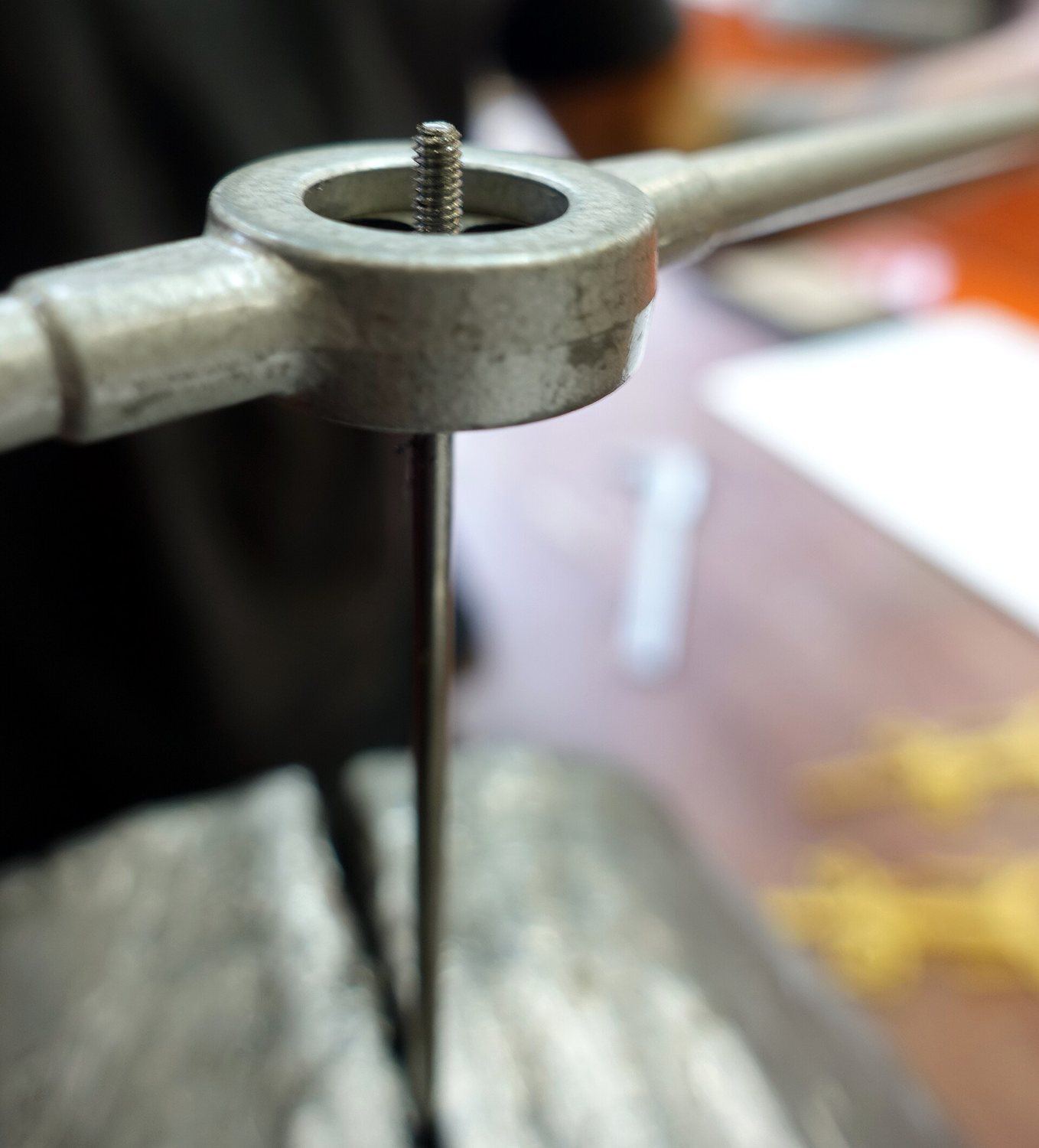Hand tapping a thread with a tap wrench.