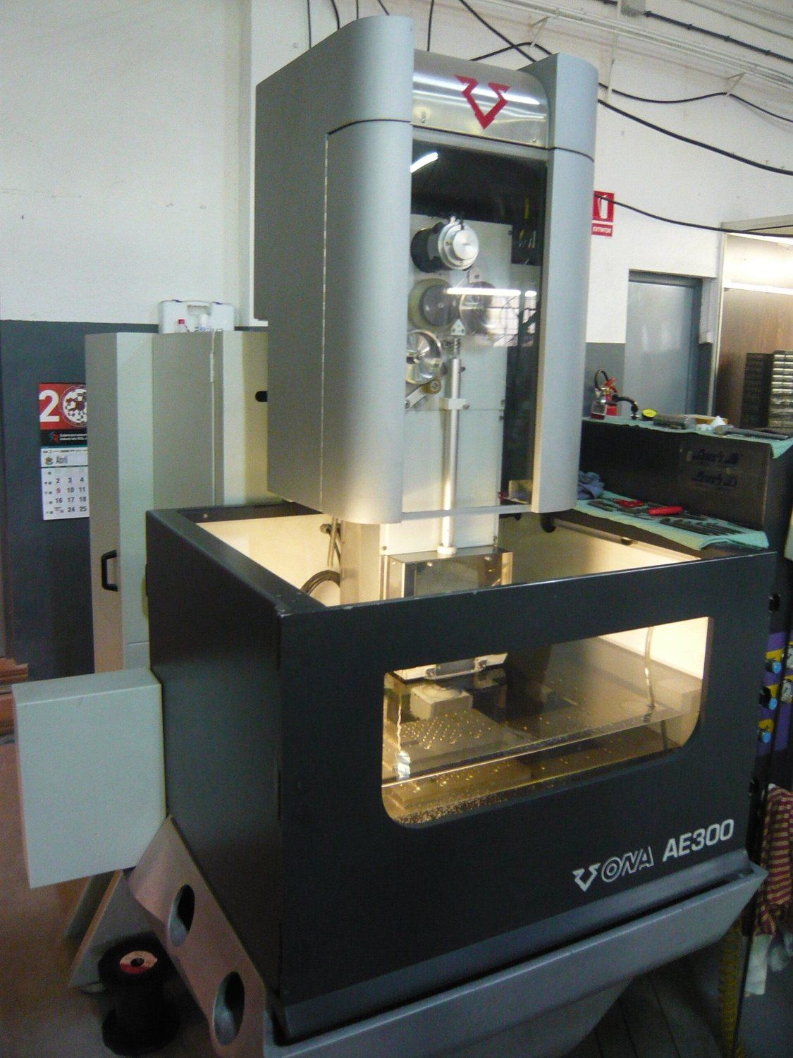 Wire EDM machine with work tank and wire guides.
